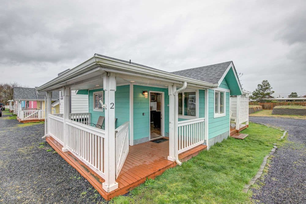 Cottage 2 exterior — teal with white trim and covered porch